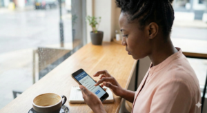 Young Nigerian using smartphone to take online survey attentively.